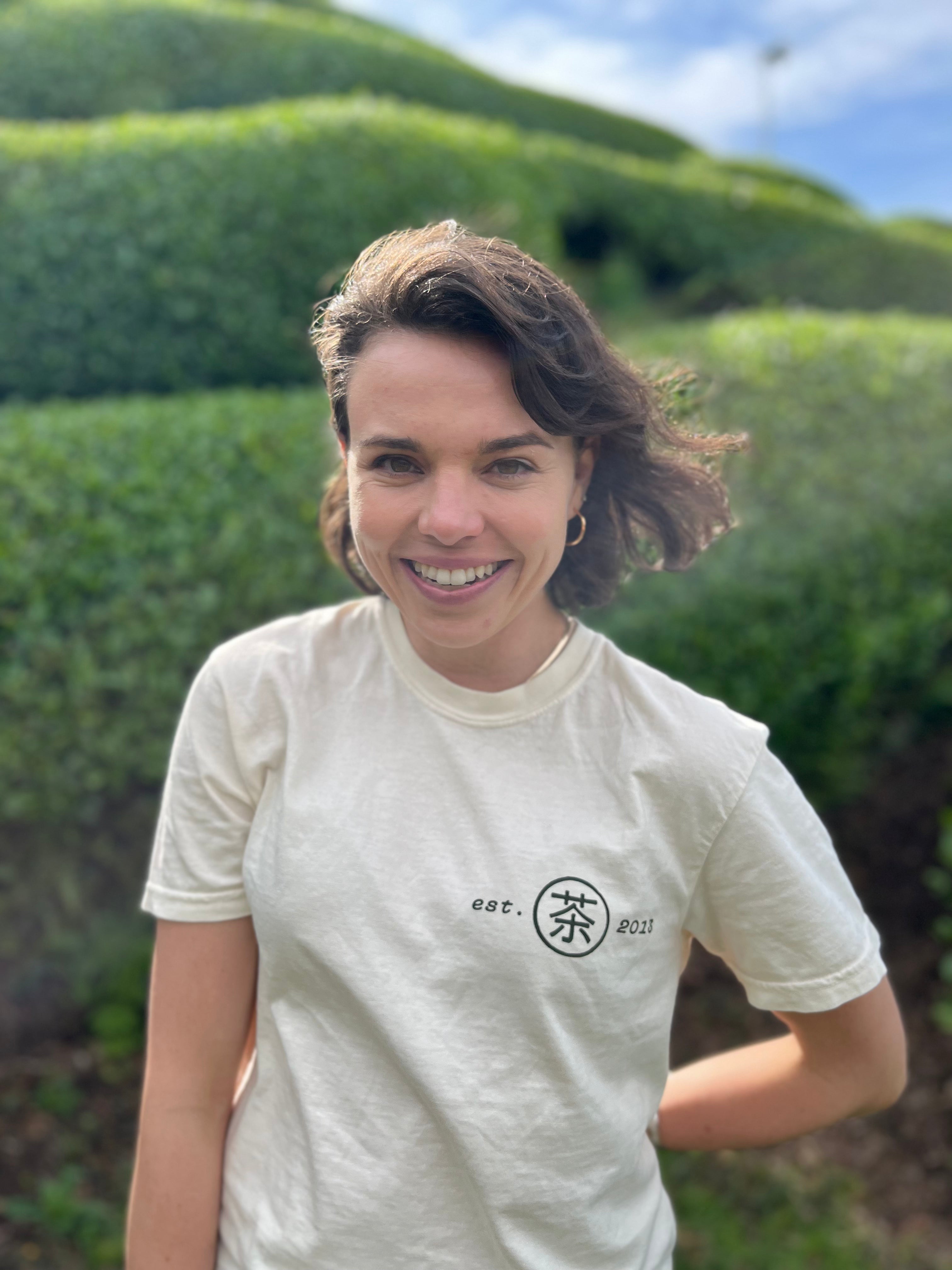 Woman wearing Mizuba Matcha tshirt standing in front of the matcha leaf fields