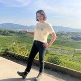 Woman stands in front of a Japanese tea field wearing a cream colored Mizuba Tea Co shirt