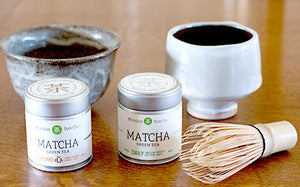 matcha tins, bowl, and whisk on a table