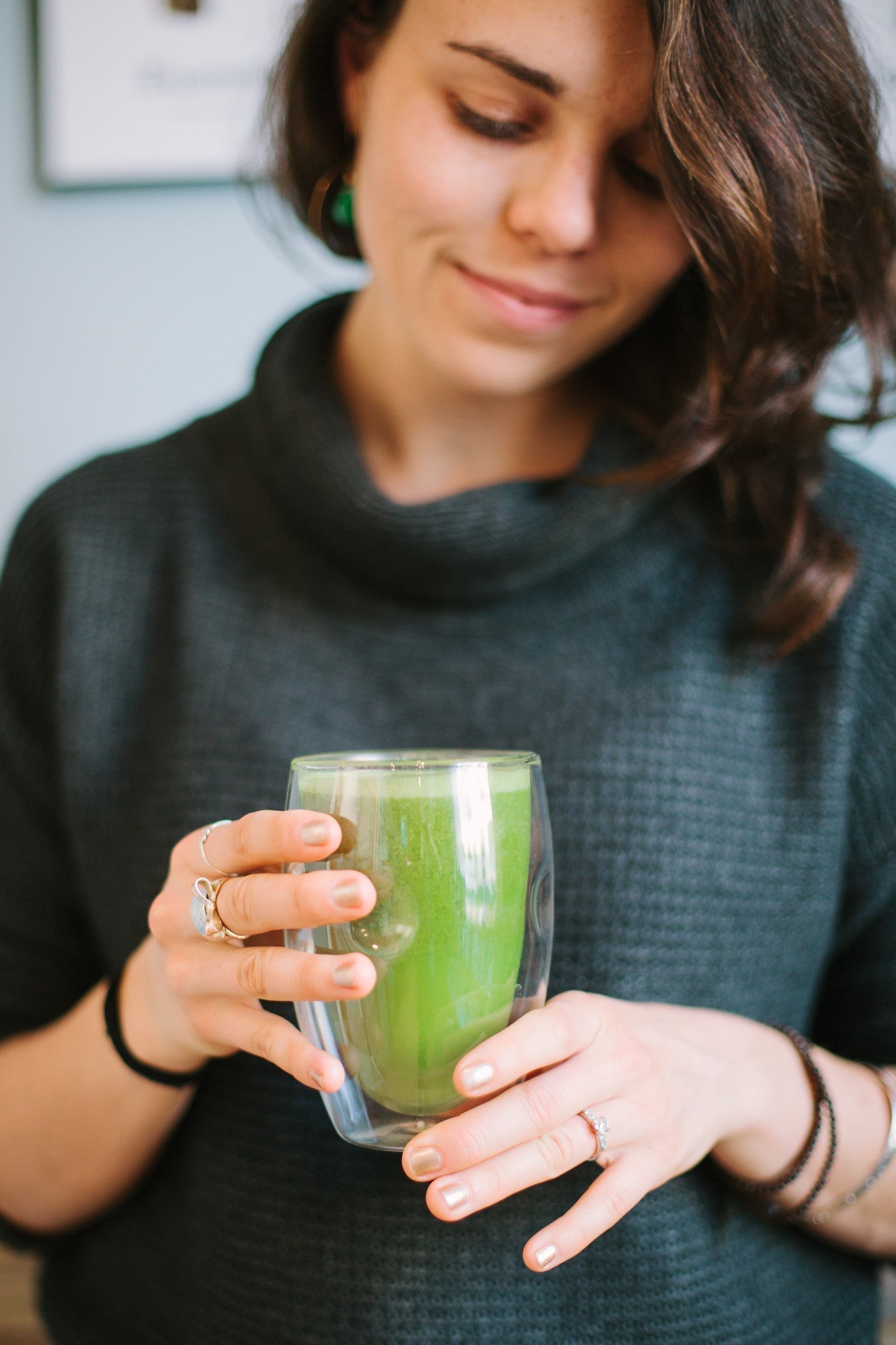 A woman holding a matcha green tea after making it