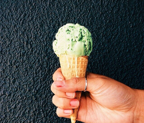 Hand holding ice cream cone with matcha green tea flavor