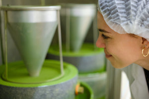 Woman smiles while looking at a Japanese matcha green tea stone mill