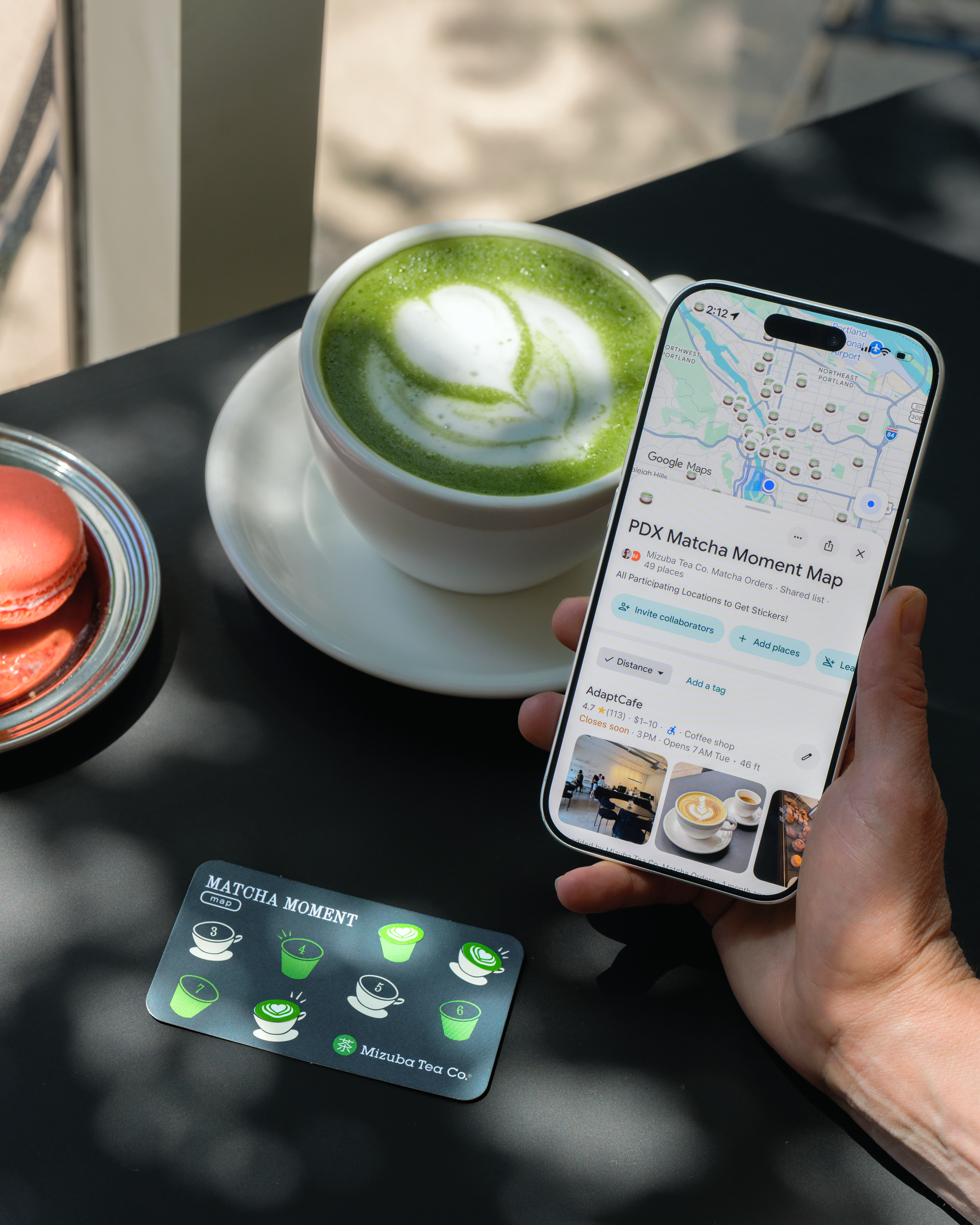 A person showing their phone on a maps app with directions to PDX Matcha Moment with a Mizuba Tea Gift Card on the table. 