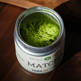 Tin of Yama Mizuba Matcha powder on a wooden surface.