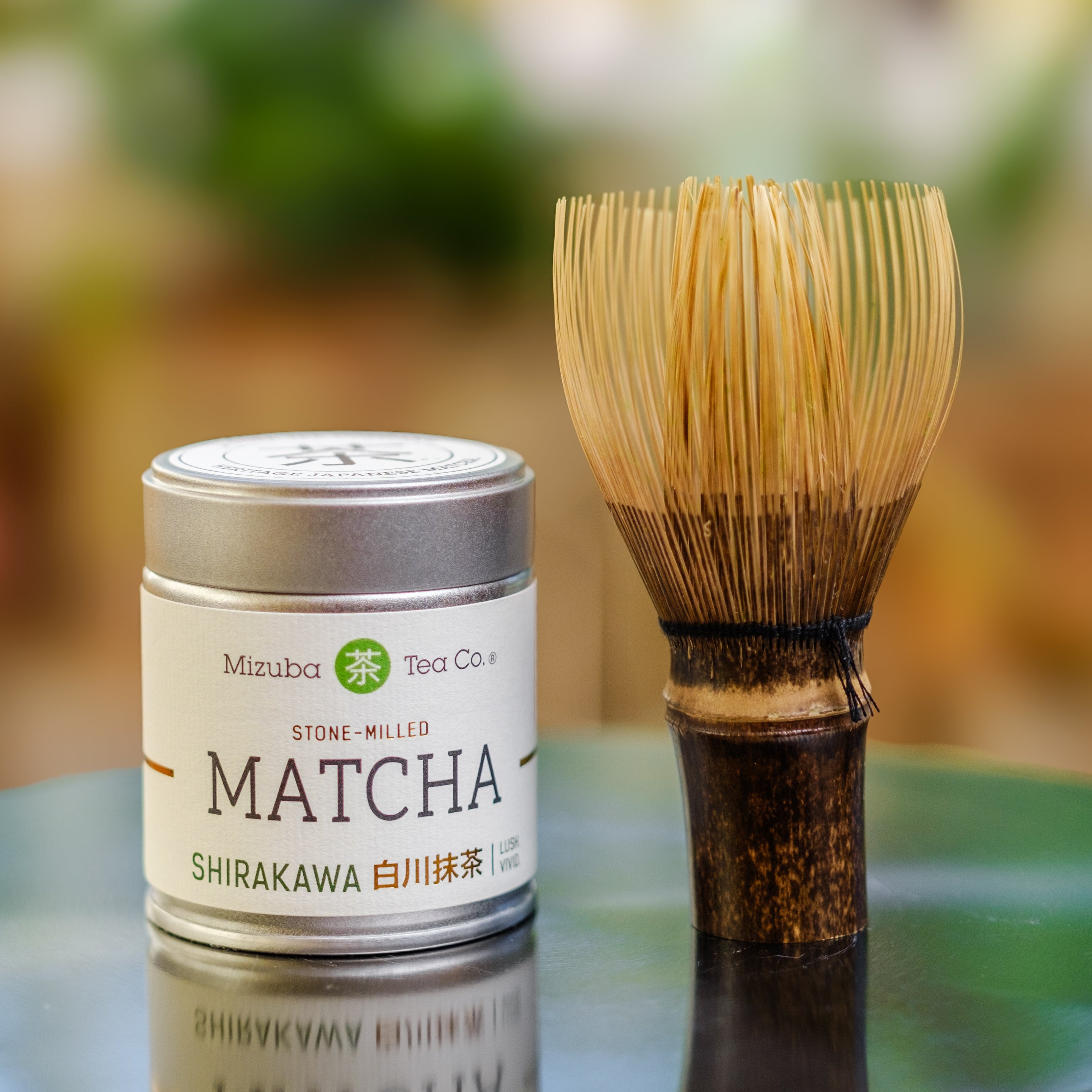 A tin of Mizuba Tea Co. Shirakawa Matcha green tea paired with a handmade dark wood chasen whisk - Mizuba Tea Co.