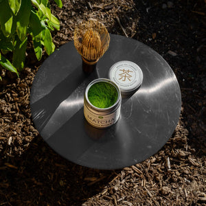 Shirakawa Matcha on a plate next to a matcha whisk 