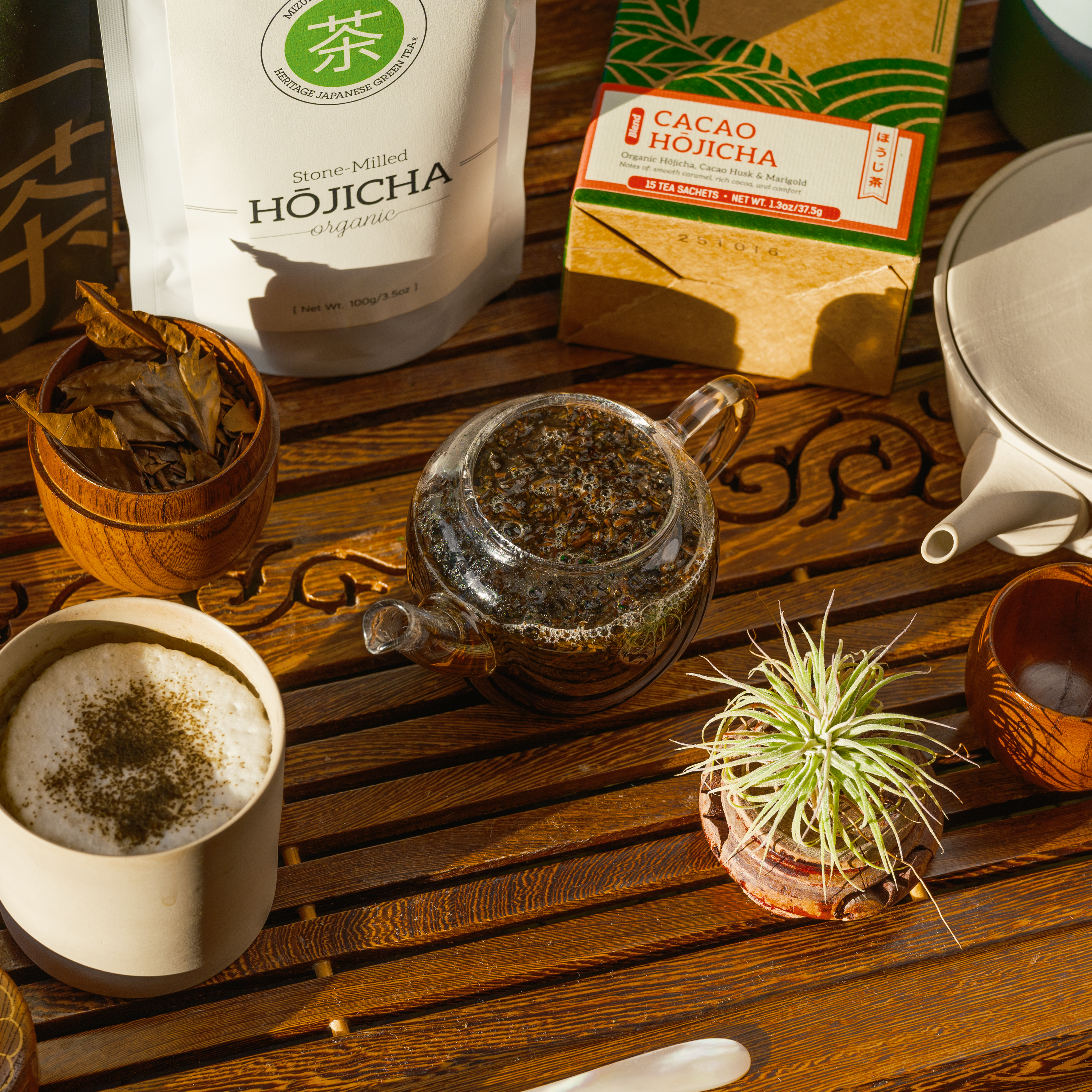 Different styles of hojicha tea on a tray. Powderered hojicha, loose leaf, and cacao hojicha tea sachets by Mizuba Tea Co.