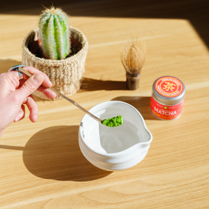 A hand uses a chashaku matcha scoop to lower powdered green tea into a chawan tea bowl – Mizuba Tea Co.