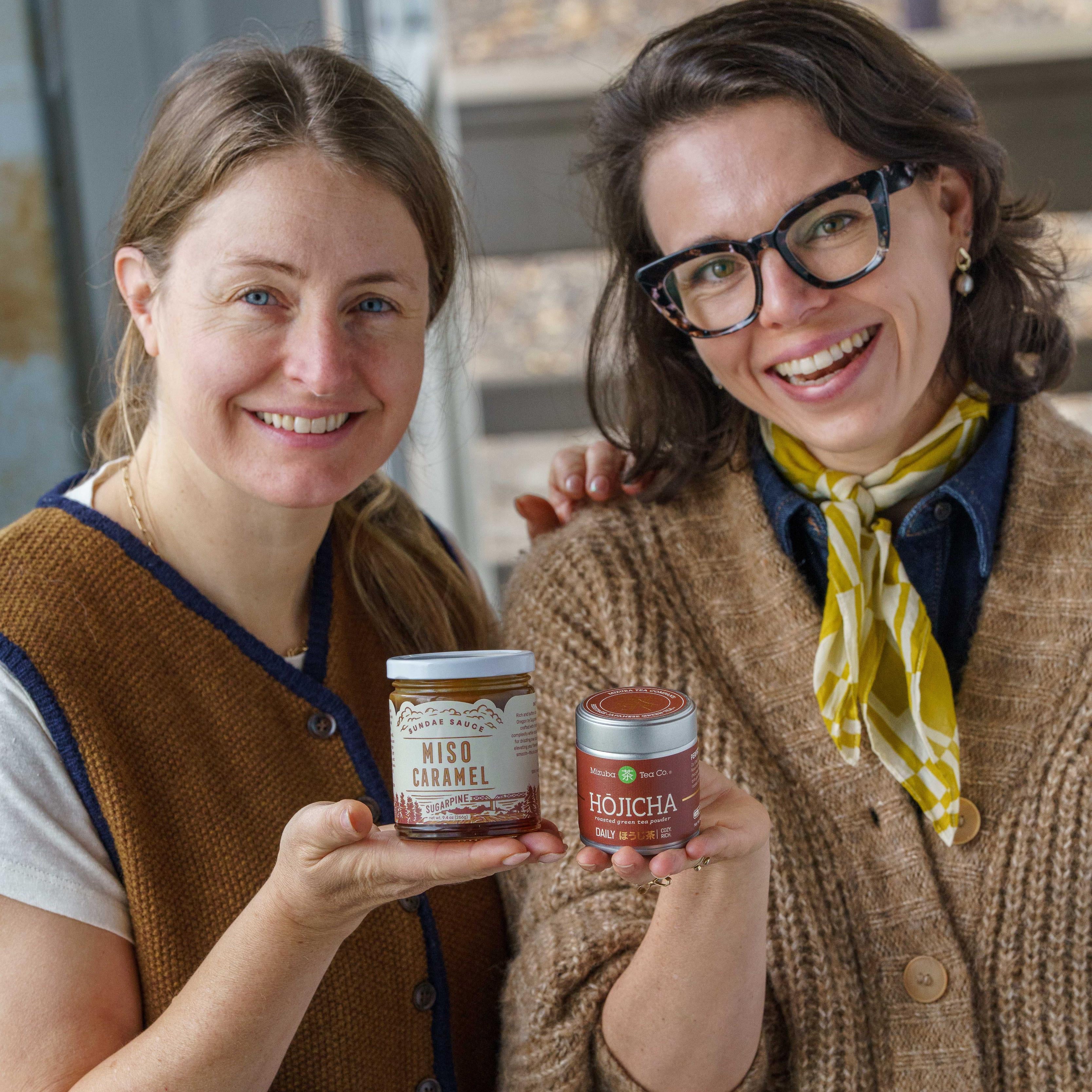 The founder of Sugarpine Drive-in and Mizuba Tea Co. hold their respective gourmet food products: miso caramel sauce and hojicha powder.