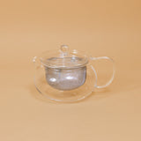 Japanese glass tea pot by Hario sits on a yellow background