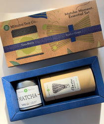 Mizuba Tea Co. Matcha Moment Essential Set gift box, showing the illustrated kraft paper lid and the blue tray containing a Mizuba Yama matcha tin and a bamboo chasen whisk.