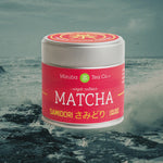 A tin of Mizuba Matcha highlighted over a video of crashing ocean waves